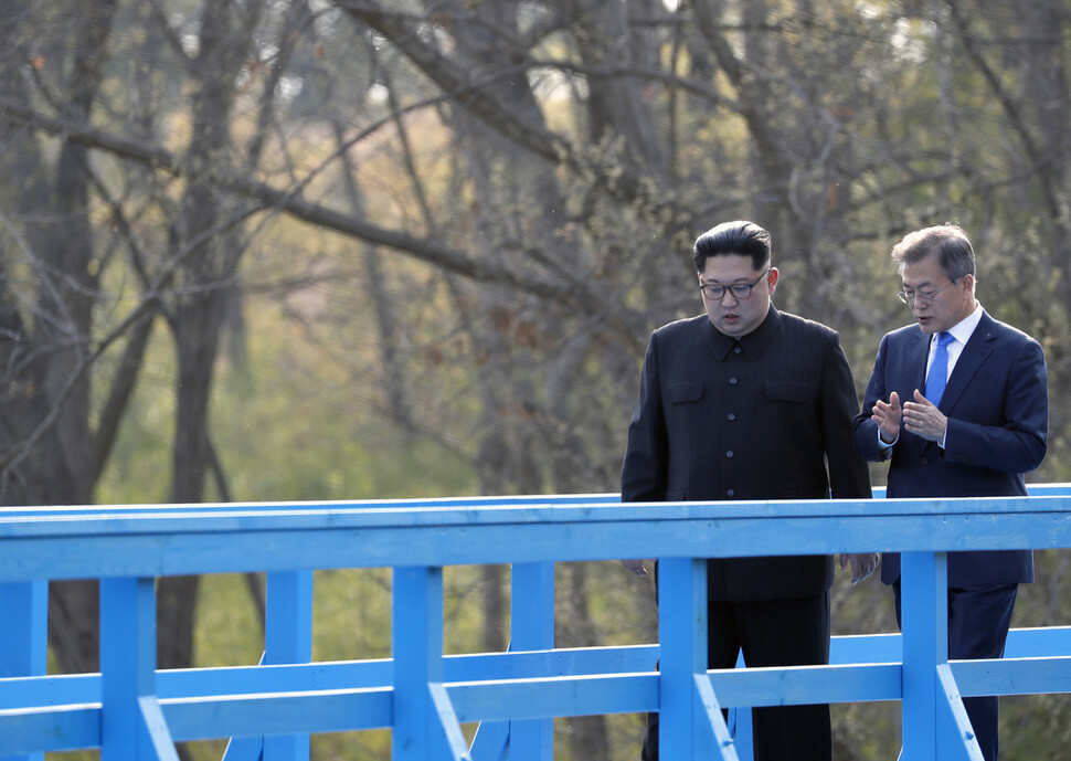 President Moon Jae-in speaks to North Korean leader Kim Jong-un as the two take a friendly stroll across a pedestrian bridge in Panmunjeom during their summit on Apr. 27.
