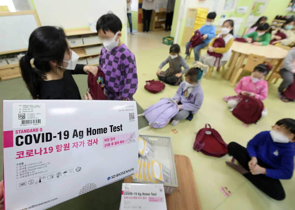Students at a preschool in Seoul’s Guro District take turns picking up rapid antigen COVID-19 test kits Tuesday. (pool photo)