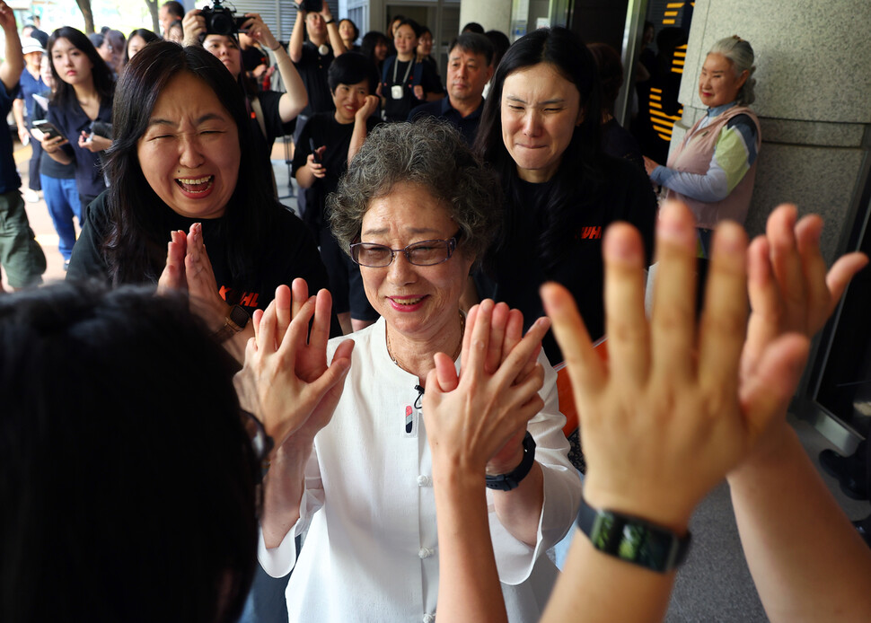61년 전 자신을 성폭행하려던 남성의 혀를 깨물어 중상해 혐의로 유죄 판결을 받았던 최말자(79)씨(흰옷 입은 이)가 2025년 7월23일 부산 연제구 부산지방법원에서 열린 재심 첫 공판을 마치고 법정을 나서며 한국여성의전화 등 여성단체 회원들과 함께 손을 맞대며 기뻐하고 있다. 이날 검찰은 “정당방위가 인정된다”며 무죄를 구형했다. 연합뉴스