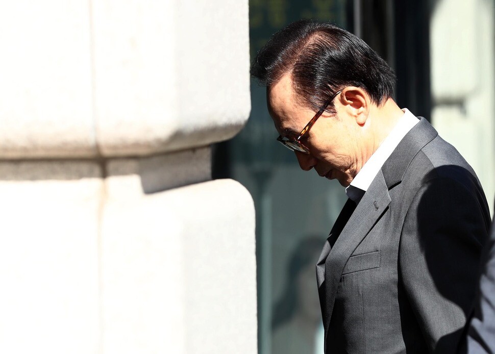 Former President Lee Myung-bak walks into his office in the Gangnam district of Seoul with his head bowed on Sept. 29.  NIS records uncovered by a Hankyoreh 21 investigation show that the spy agency pressured advertisers and broadcasters to sideline celebrities who were critical of Lee’s administration. (Yonhap News)