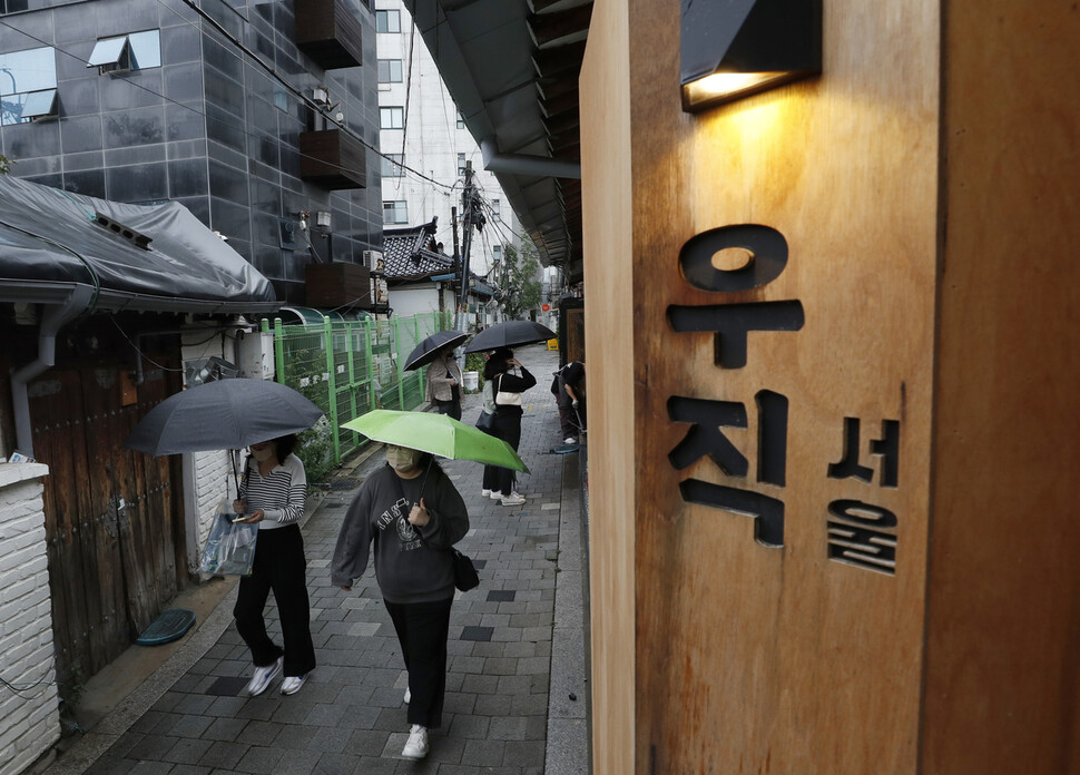 서울 종로구 자하문로에 자리한 음식점 ‘우직 서울’ 간판 아래로 시민들이 지나가고 있다.