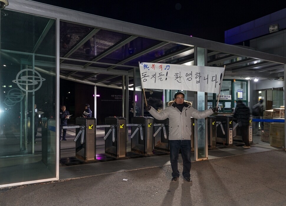이른 아침 복직하는 동료들을 환영하려고 직접 만든 펼침막을 들고 공장 앞에 서 있는 김수경씨. 김수경씨는 2015년에 먼저 복직했다.