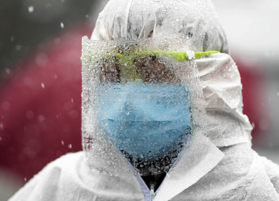 우한에 눈이 내린 2월15일 방역복을 입은 공안이 ‘우한 리빙룸’이라 부르는 임시병동을 지키고 있다.