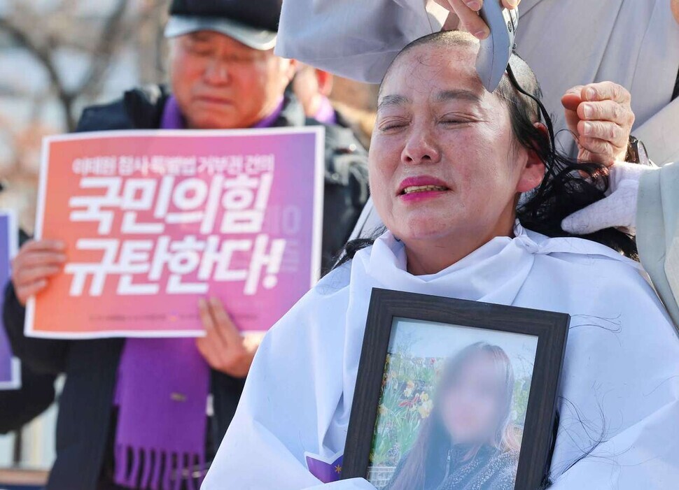 Family members of those who died in the tragic crowd crush in Itaewon on Oct. 29, 2022, gather outside the presidential office in Seoul on Jan. 18 and shave their heads in protest of the ruling People Power Party’s recommendation that the president use his veto power on a special act for investigating the disaster. (Yonhap)