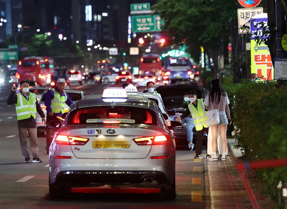 2022년 5월12일 밤 서울 강남역 인근 임시승차대에서 택시 승차지원단이 시민들의 탑승을 돕고 있다. 연합뉴스