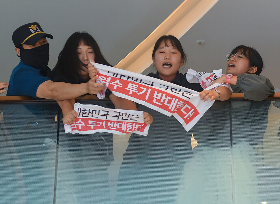 A police officer grabs a banner from a college student who attempted to enter the Japanese Embassy in Seoul during a protest of Japan’s plan to dump contaminated water from the Fukushima nuclear plant on Aug. 24. (Yonhap)