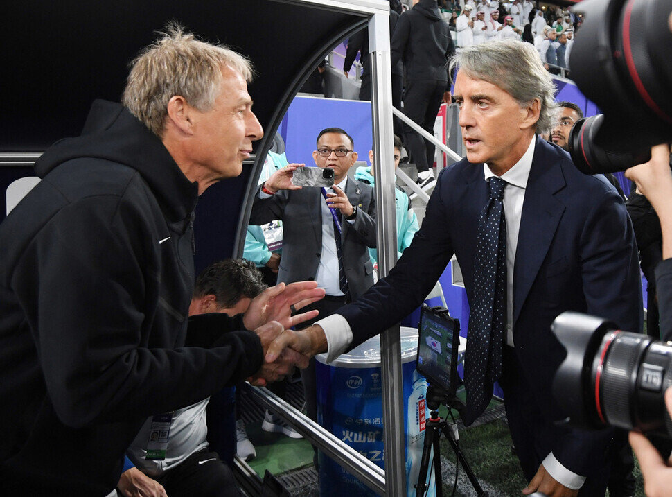 Jürgen Klinsmann (left), who manages the Korean men’s national football team, speaks to Roberto Mancini, who manages the Saudi Arabia national team, ahead of their teams facing off in Qatar for the 2023 AFC Asian Cup on Jan. 30 (Korea time). (Yonhap)