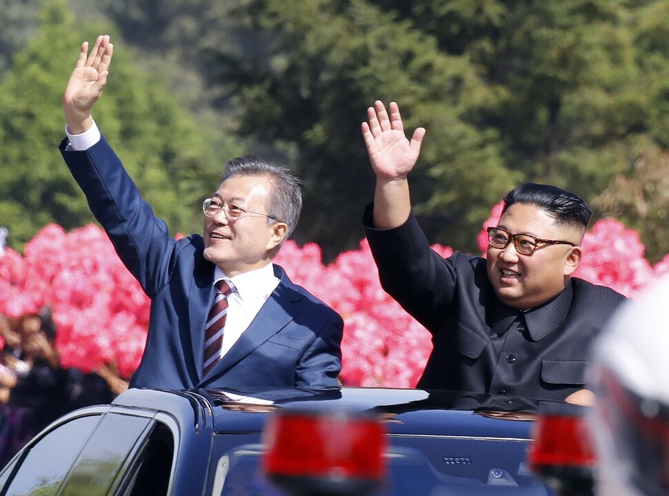 South Korean President Moon Jae-in and North Korean leader Kim Jong-un wave to Pyongyang residents on the streets during a motor convoy through the city on Sept. 18. (photo pool)