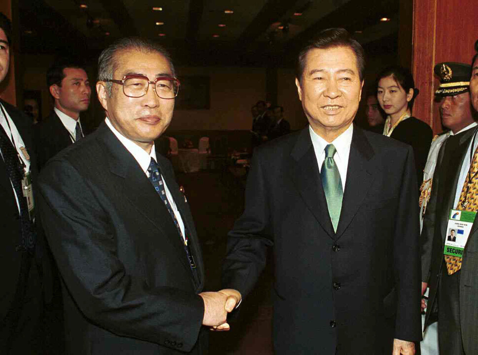 Japanese Prime Minister Keizo Obuchi and South Korean President Kim Dae-jung, the two figures behind the declaration of a partnership between Japan and South Korea, shake hands ahead of a summit in the Philippines in November 1999. (Hankyoreh file photo)