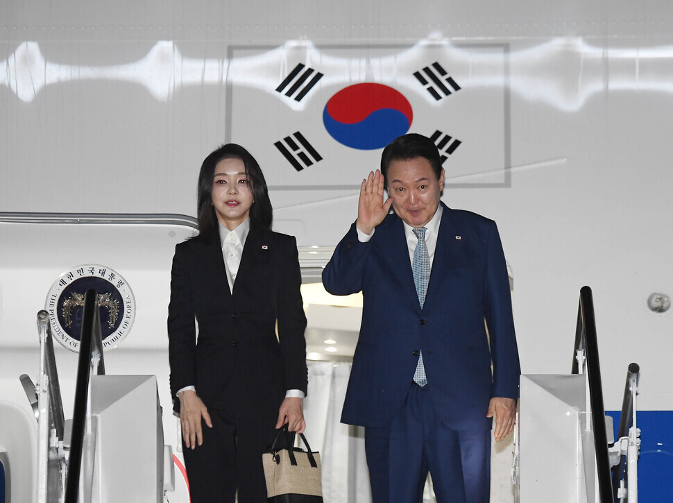 South Korean President Yoon Suk-yeol and first lady Kim Keon-hee wave goodbye as they board the presidential plane in Bali, Indonesia, on Nov. 15 after wrapping up a six-day tour of Southeast Asia. (Yoon Woon-sik/The Hankyoreh)