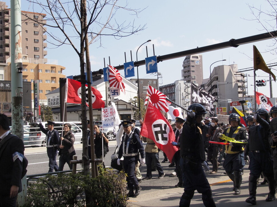 일본 ‘재일 특권을 용납하지 않는 시민 모임’ 회원들이 욱일기와 하켄크로이츠가 새겨진 깃발을 들고 행진하고 있다. 영화 ‘카운터스’ 갈무리.