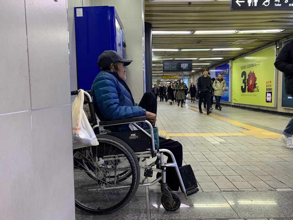 장애인 홈리스인 김한수씨가 12월4일 오후 서울역 2번 출구 쪽 지하도에서 사람들이 오가는 모습을 지켜보고 있다. 장수경 기자