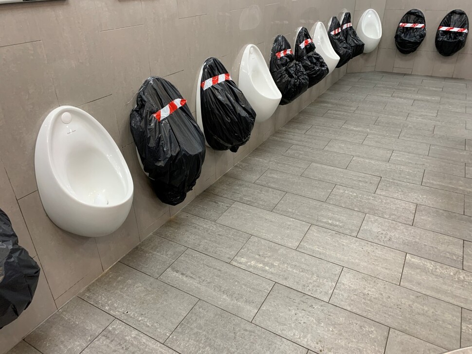 영국 켄트주 메이드스톤의 한 고속도로 휴게소 화장실 소변기가 일정 간격을 두고 사용하도록 비닐로 가려져 있다.