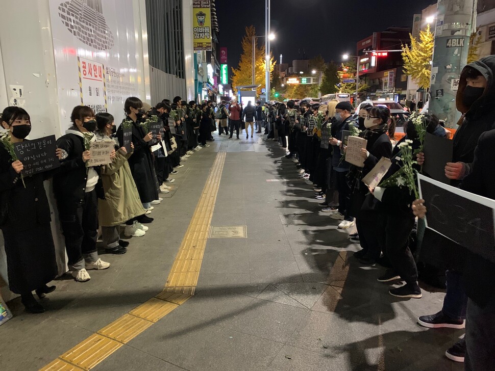 Young people in black hold placards as part of a demonstration near Itaewon Station, Seoul, on Friday, Nov. 4. The demonstration was held to commemorate the victims of the Itaewon crowd crush and demand that the South Korean government be held responsible for the disaster. (Photo provided by John R. Eperjesi)