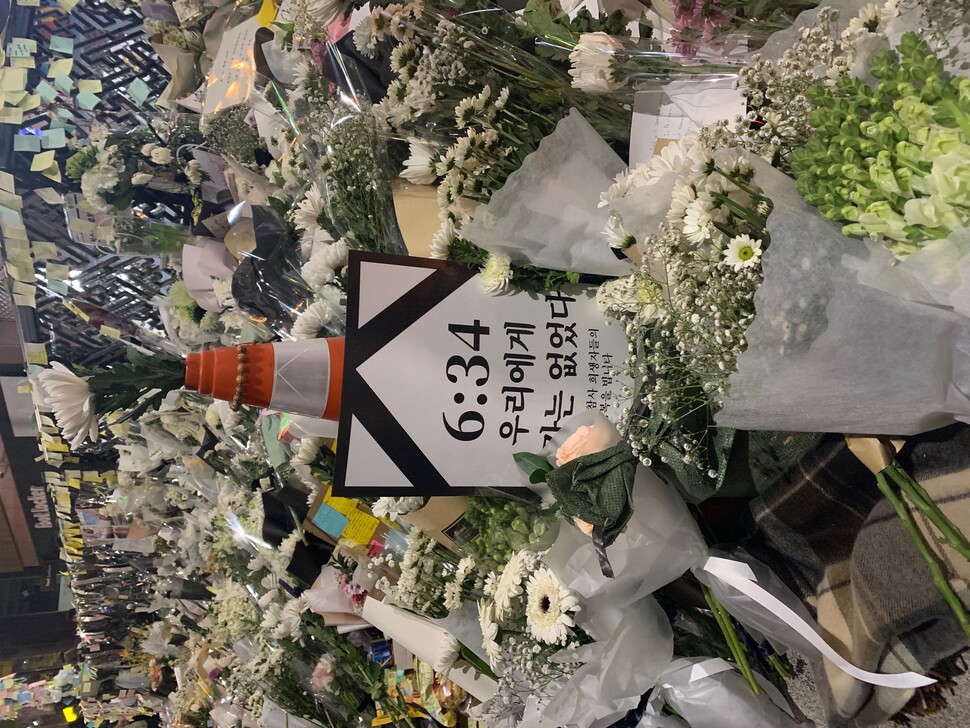 This poster designed to resemble a funeral photo bearing the slogan “The government wasn’t there for us” was lying amidst bouquets commemorating the victims of the Itaewon crowd crush near Itaewon Station, Seoul, at 6:34 pm on Friday, Nov. 4. (Photo provided by John R. Eperjesi)