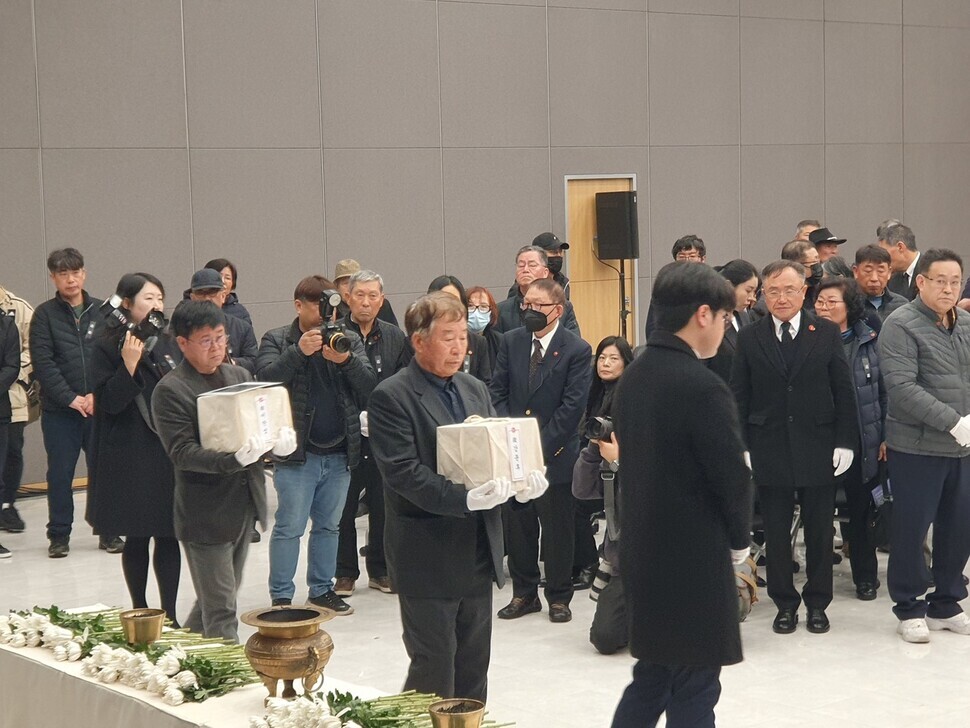 Two sets of remains of those killed during the Jeju April 3 Incident are carried to their resting place in the hall for enshrining ashes at the Jeju 4.3 Peace Park on Feb. 20, 2024. (He Ho-joon/The Hankyoreh)  