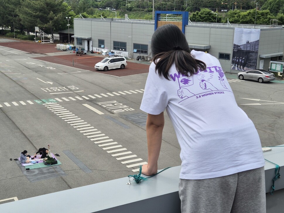 고공농성 500일을 열흘 앞둔 2025년 5월11일, 박정혜씨와 연대하러 온 시민들이 돗자리를 펴고 앉아 손을 흔들자 박정혜씨가 이들을 바라보고 있다. 신다은 기자