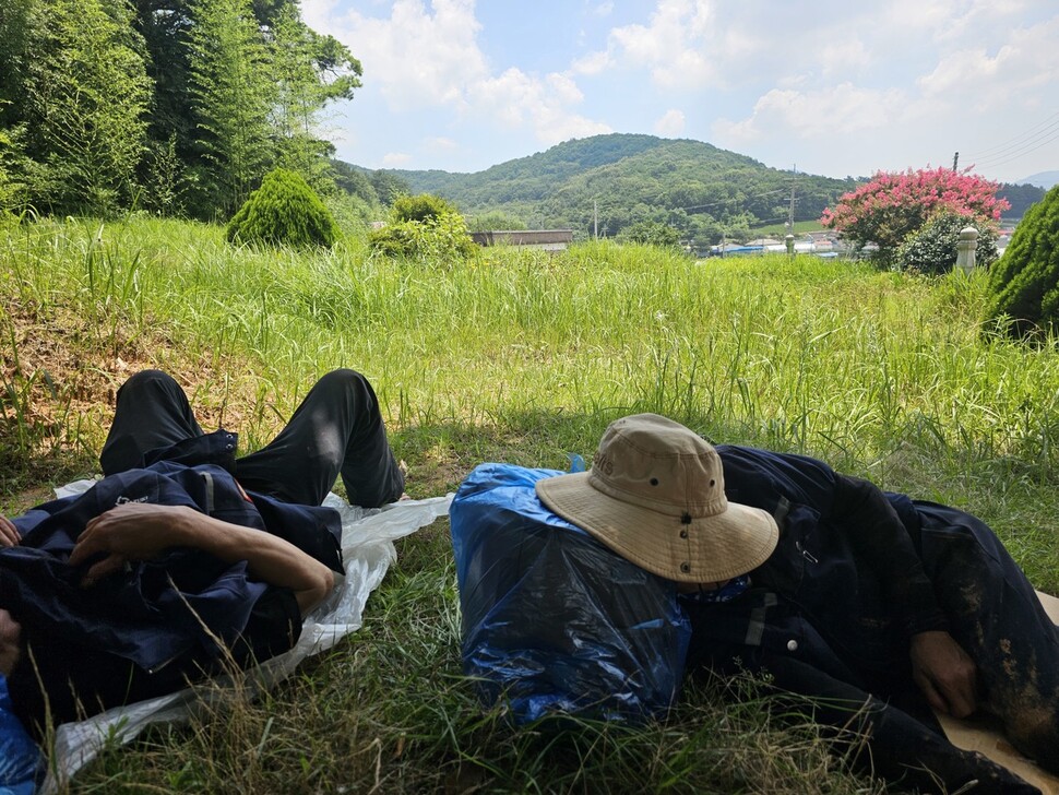 2025년 7월24일 낮 12시∼오후2시 점심시간에 수박밭 인근 그늘에서 휴식을 취하는 이주노동자들. 채윤태 기자