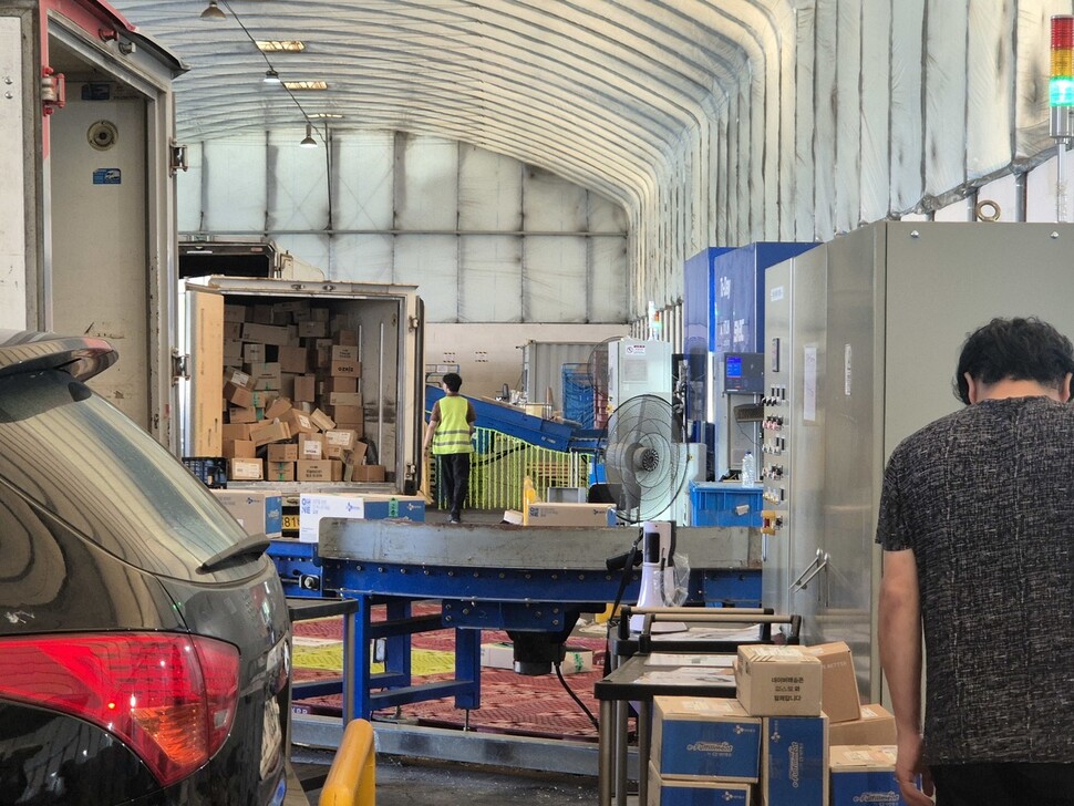 2025년 7월22일 서울의 한 분류터미널에서 ‘2회전’ 배송 물량이 출고되고 있다. 차량 옆에 있는 선풍기는 택배 분류 인원 몫이고 기사들을 위한 것은 따로 없다. 신다은 기자