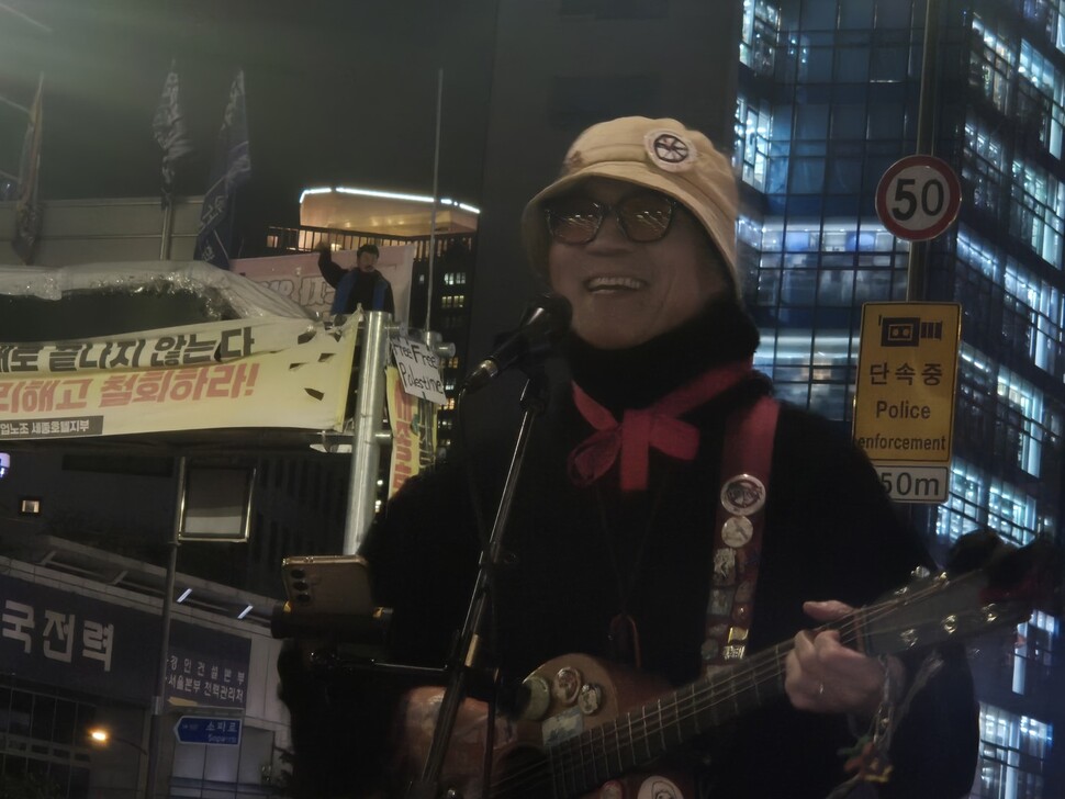 2025년 11월5일 박준 민중가수가 서울 중구 세종호텔 앞에서 고진수 세종호텔지부장을 위해 노래를 부르자 고 지부장이 지하차도 진입차단시설 위에서 손을 흔들며 화답하고 있다. 신다은 기자