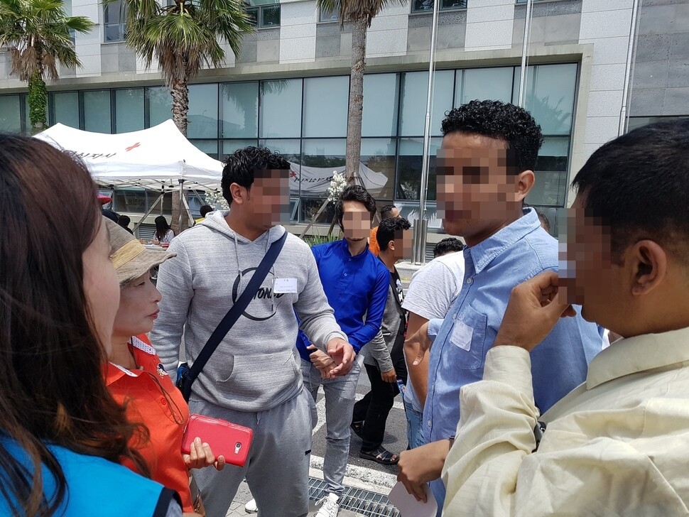 Yemeni asylum seekers talk to Jeju residents looking to hire extra work hands at the Jeju Office of Immigration on June 18. (Huh Ho-joon