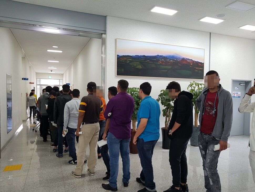 Yemeni asylum seekers stand in line to attend an employment presentation at the Jeju Immigration Office on June 18. (Huh Ho-joon