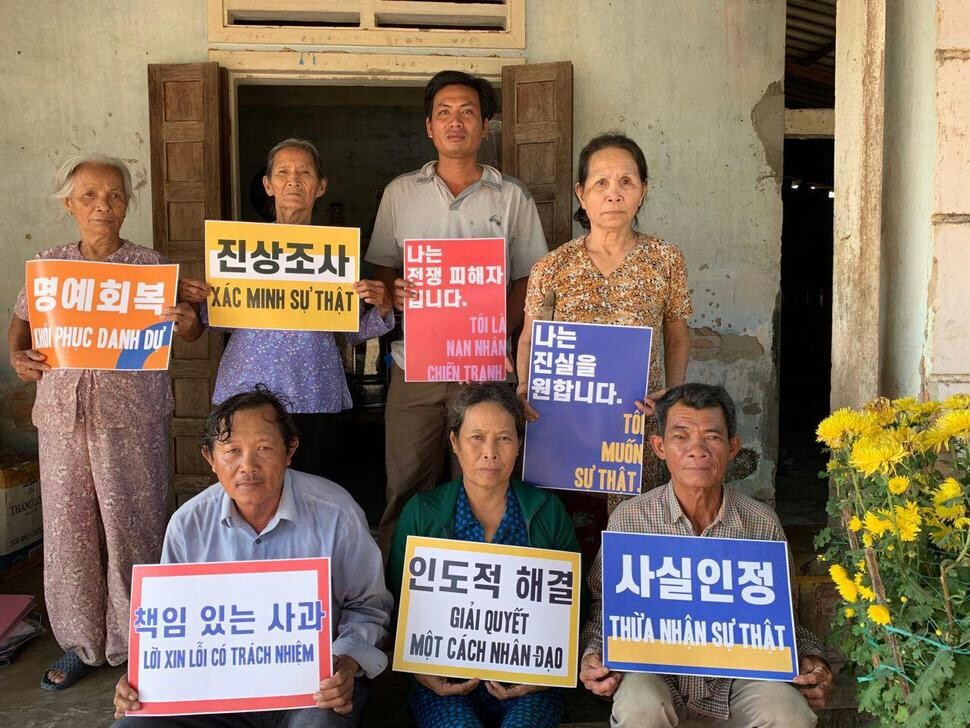 Surviving family members of civilian victims slaughtered by South Korean troops hold up placards demanding an apology and reparations from the South Korean government. (provided by the Korea-Vietnam Peace Foundation)