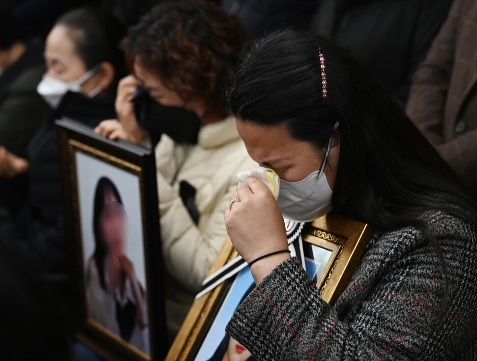 이태원 참사 유가족들이 11월22일 오전 서울 서초구 민주사회를 위한 변호사모임(민변) 대회의실에서 열린 입장발표 기자회견에서 숨진 자녀의 영정 사진을 품에 안은 채 눈물을 흘리고 있다. 공동취재사진