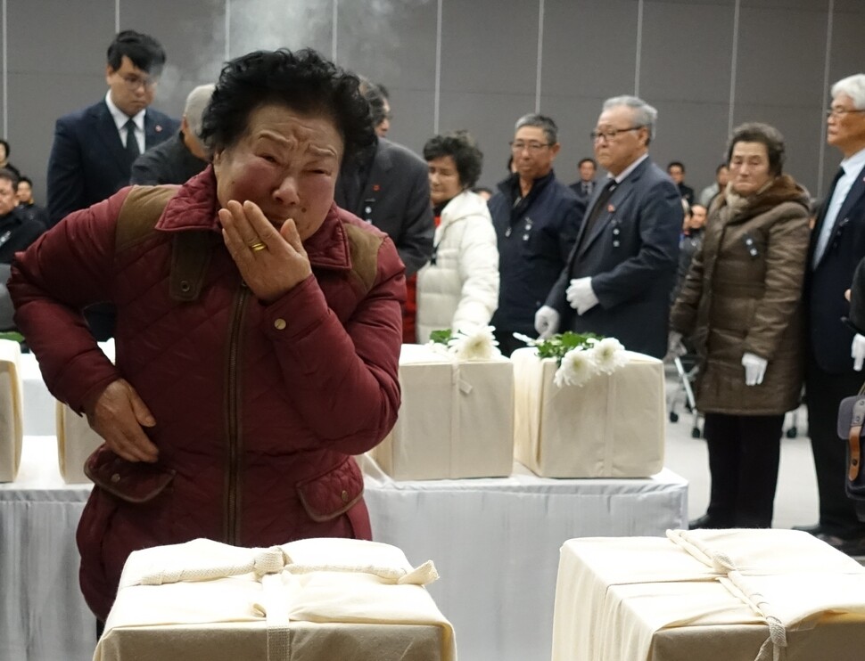 A surviving family member of a Jeju Uprising victim grieves in front of a set of recently identified remains of at the Peace Education Center in Jeju Apr. 3 Peace Park in Jeju City on Nov. 22.