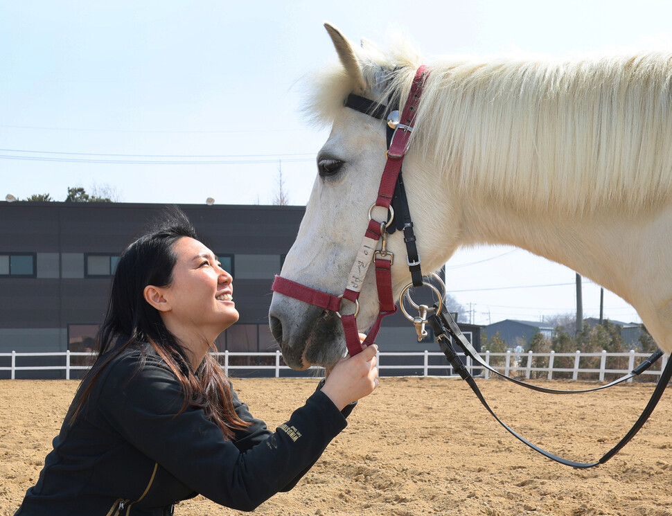 이수현 일산승마 마음치유&트레이닝센터 대표가 마장에서 백설이와 눈을 맞추고 있다.