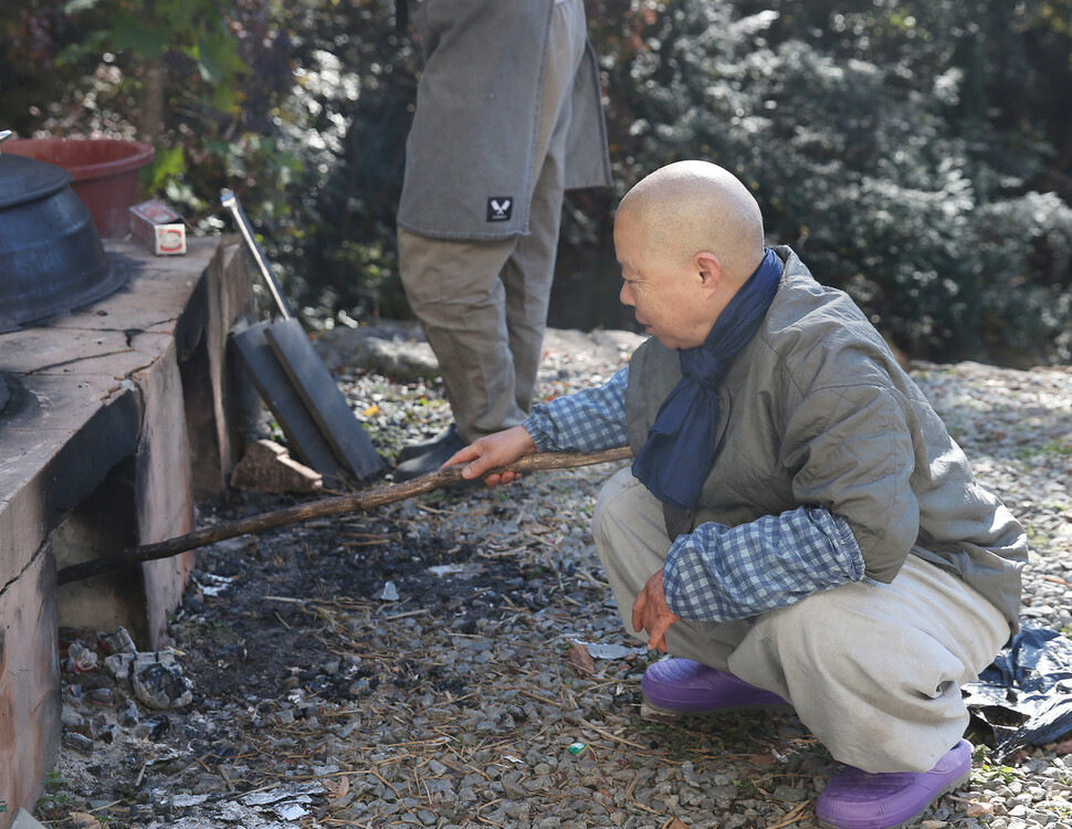 정관 스님이 음식 준비를 위해 불을 지피고 있다. 박미향 기자
