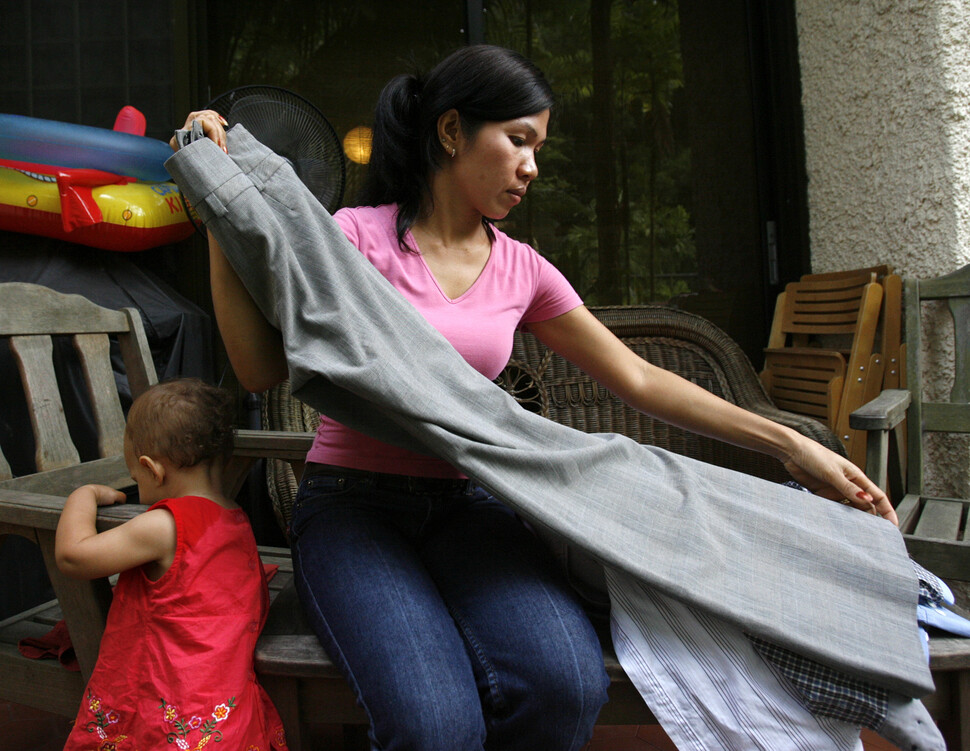 필리핀 출신의 36살 가사노동자가 싱가포르의 한 가정집에서 빨래를 정리하고 있다. 아이 양육, 환자 돌봄 등을 이주여성을 고용해 해결하는 돌봄 노동의 이주화 현상이 점점 심해지고 있다. REUTERS