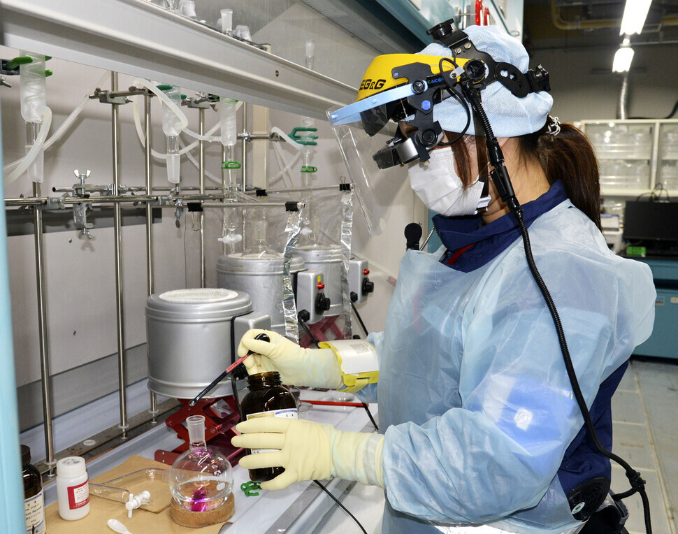 A person, in June, analyzes and measures the contaminated water scheduled to be released from the Fukushima Daiichi nuclear plant. (Yonhap)