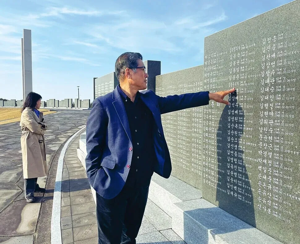 Heo Ho-joon points to a memorial stone bearing the names and details of victims killed in the Jeju April 3 Incident at Jeju 4&middot;3 Peace Park. (Lee You-jin/Hankyoreh)