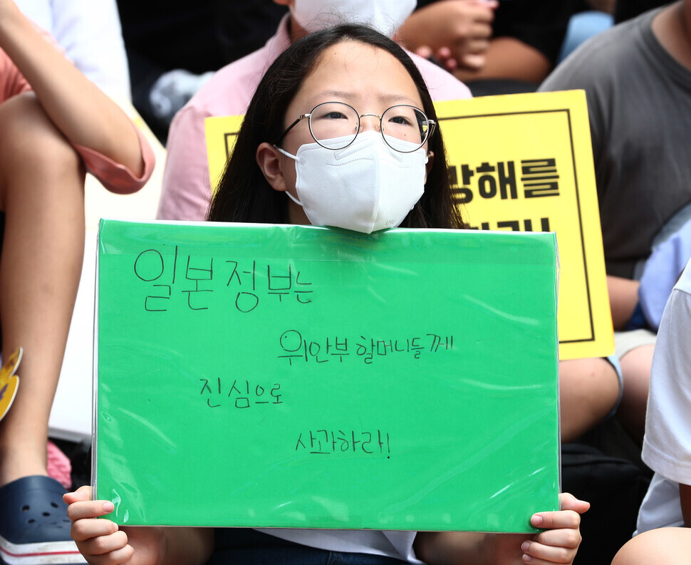 A participant in the Aug. 10 Wednesday Demonstration in downtown Seoul holds up a sign calling on the Japanese government to issue a sincere apology to Korea’s comfort women.