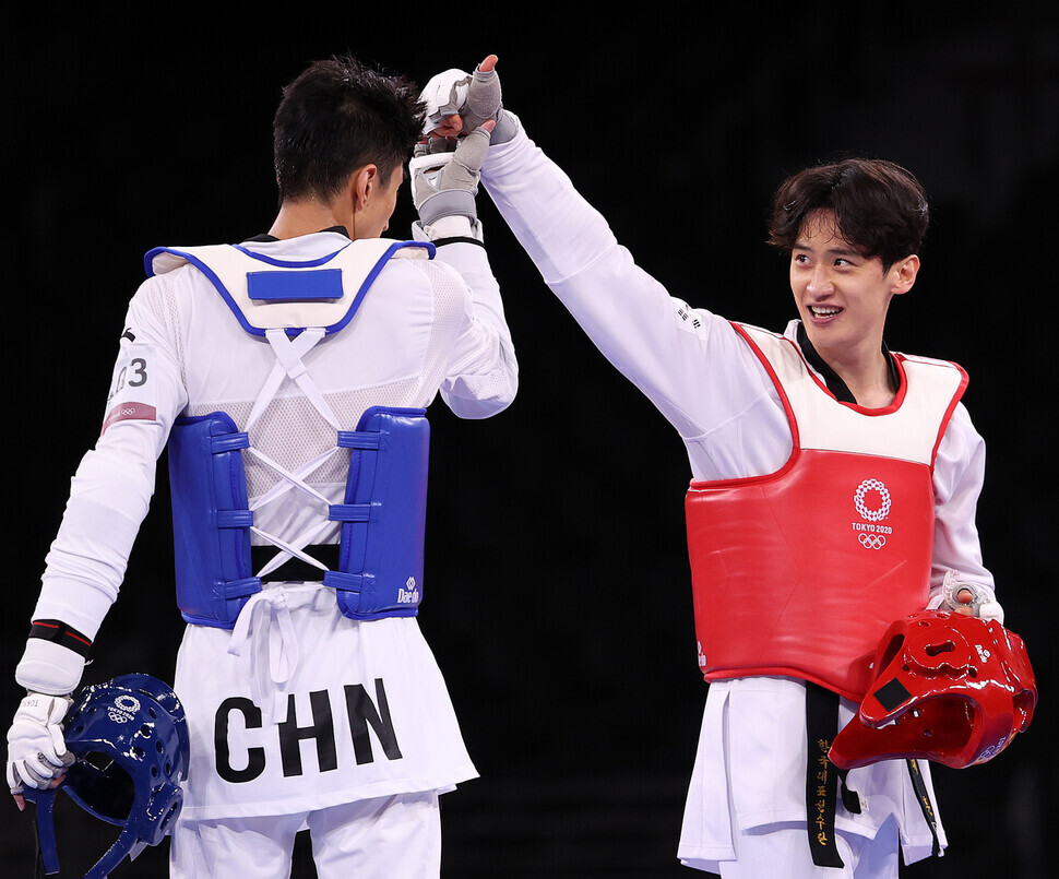 Team Korea taekwondo athlete Lee Dae-hoon gives Zhao Shuai of China a thumbs up after losing the match for the bronze medal in the men's 68-kilogram category during the Tokyo Olympics, at Tokyo's Makuhari Messe Hall, on Sunday. (Yonhap News)