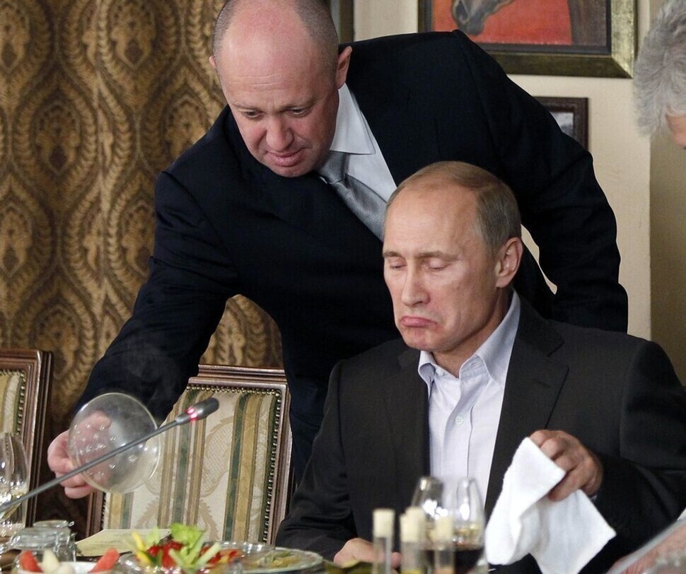 At a restaurant he owns, Yevgeny Prigozhin (left), serves food to then-Prime Minister Vladimir Putin of Russia on November 11, 2011. (AP/Yonhap)