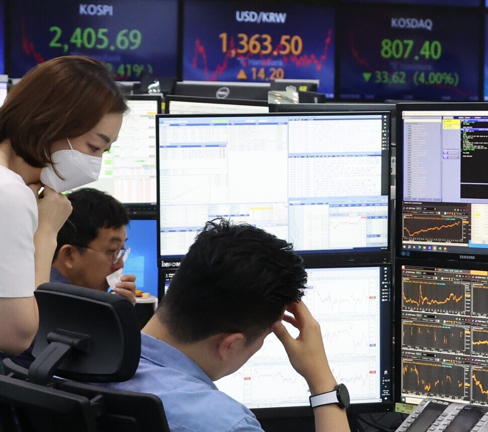 Workers in Hana Bank’s dealing room in downtown Seoul check screens on Oct. 4, when the KOSPI fell by over 2% and the won-dollar exchange rate hit 1,360 on jitters over US austerity measures. (Yonhap)