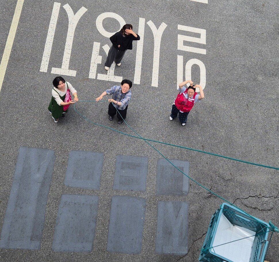 고공농성 500일을 열흘 앞둔 2025년 5월11일, 박정혜씨를 응원하러 온 시민들이 점심식사를 올려보낸 뒤 빈 도르래를 내리고 있다. 신다은 기자