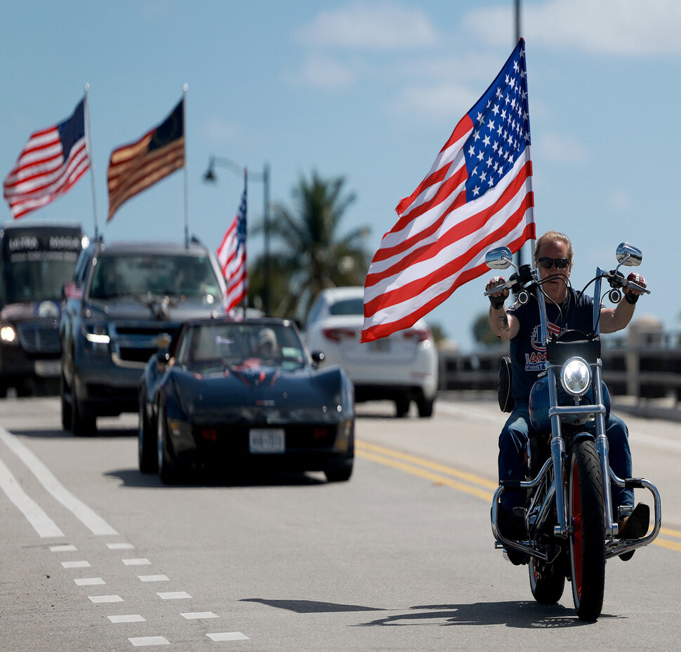 도널드 트럼프 전 미국 대통령 지지자들이 23일 그가 사는 플로리다주 팜비치의 마러라고 리조트 주변에서 오토바이와 차에 성조기를 달고 달리고 있다. 팜비치/AFP 연합뉴스