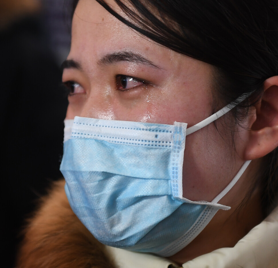 난징국제공항에서 2월11일 우한으로 향하는 의료진 남편을 배웅하는 간호사가 눈물을 흘리고 있다.