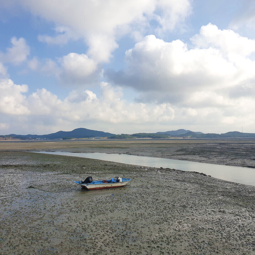 A boat sits on a mud flat after the tide has gone out. (Her Yun-hee/The Hankyoreh)